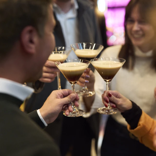 Bild von vier Personen, die mit Cocktails anstoßen.