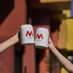 Zwei Bierkrüge vor der Fassade der Macherei München